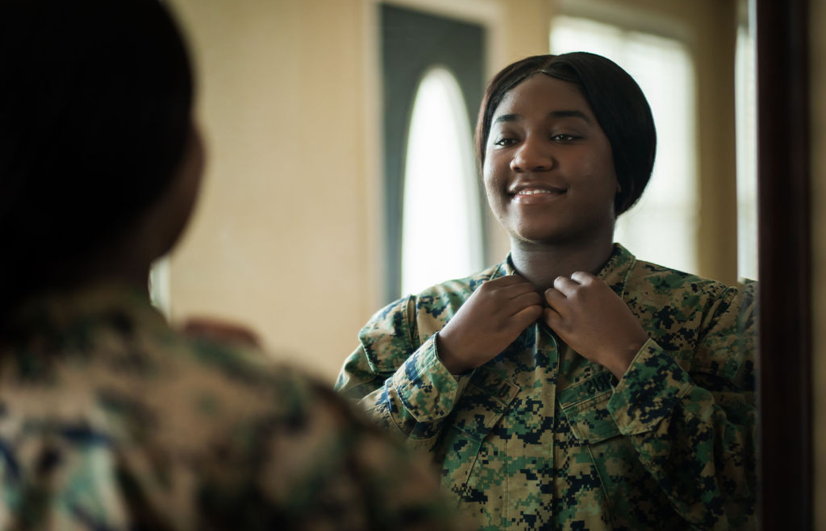 Jocelyn Harris adjusts her military uniform.